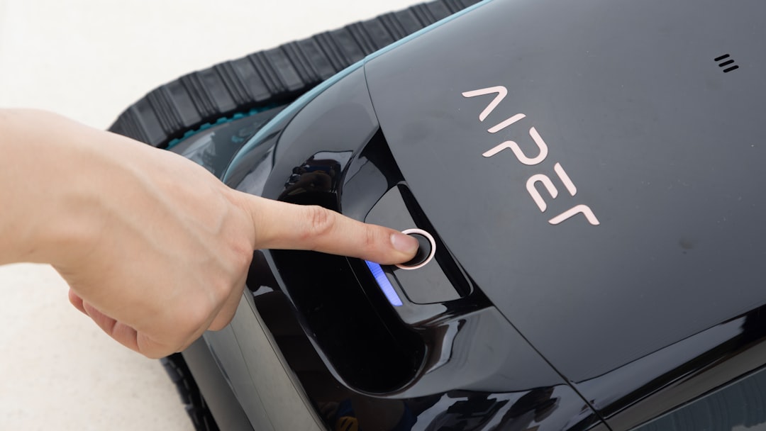 services-02 A user presses the power button to activate the Aiper Scuba N1 cordless robotic pool cleaner.